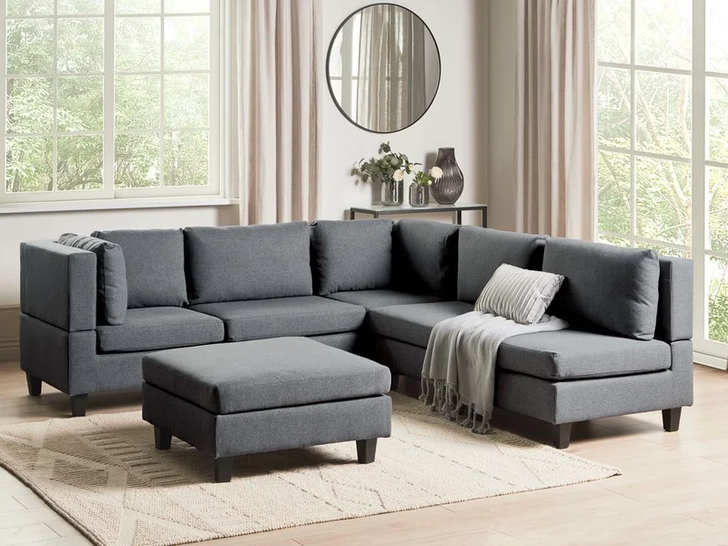 Divano componibile a 5 posti imbottito lato destro in tessuto grigio scuro con gambe nere e pouf stile moderno